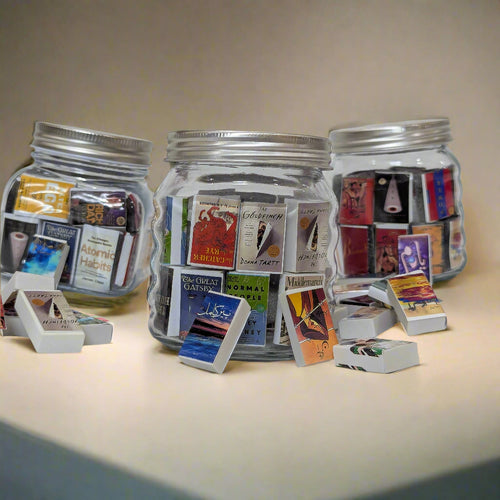 Three glass jars filled with small cards on a white background