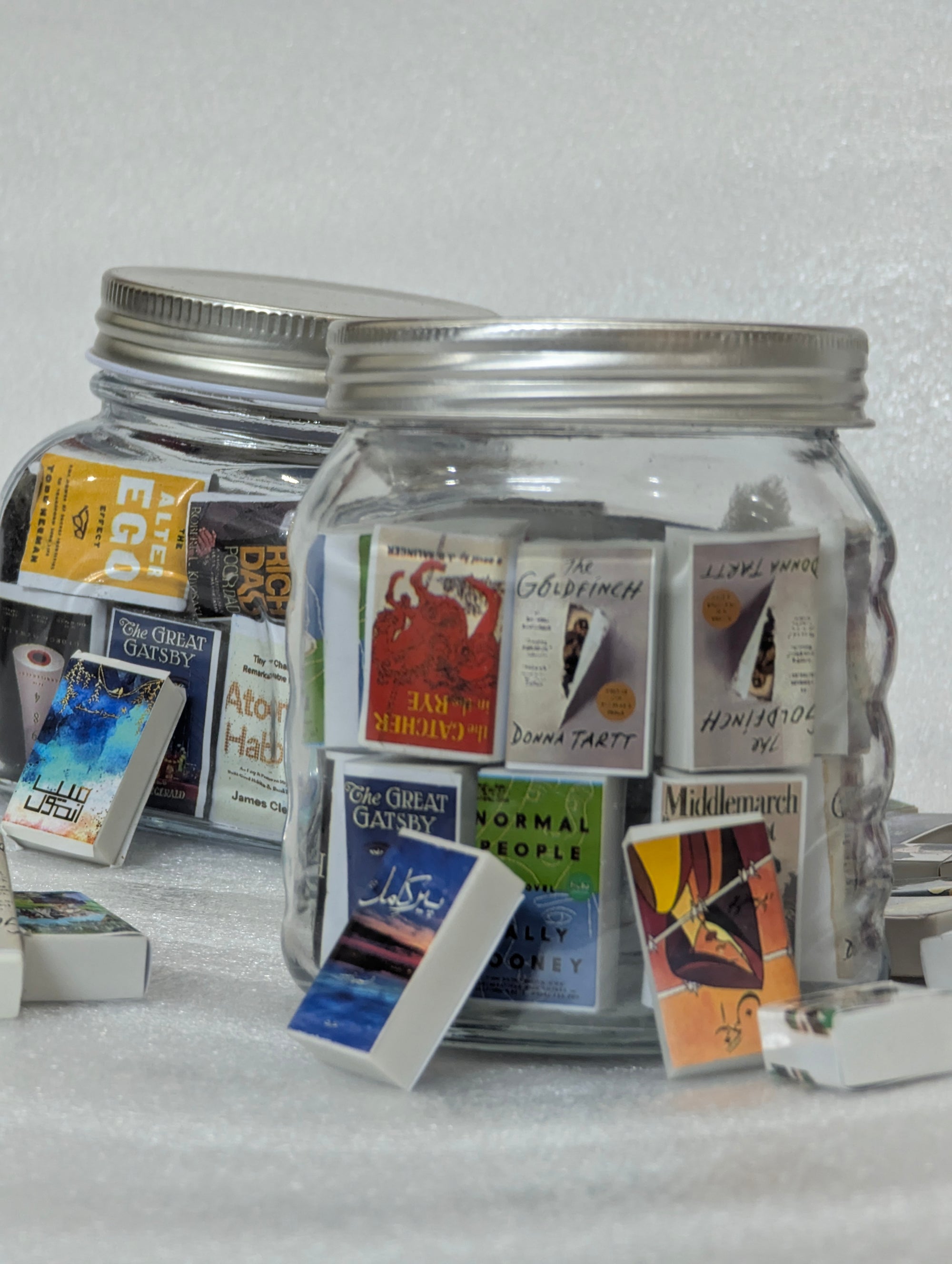 Jar filled with small book on a light gray background